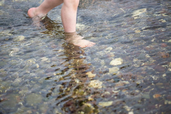 Fötter som badar i havet
